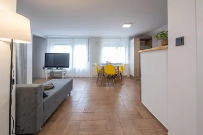 a living room with a couch and a table with yellow chairs at 2 Bedroom Apartment Sima with Seasonal Shared Pool in Ivančna Gorica