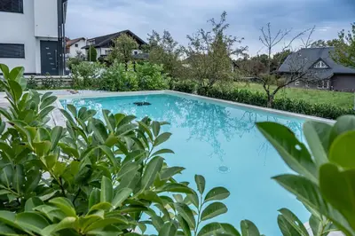 a swimming pool in a yard with plants at 2 Bedroom Apartment Sima with Seasonal Shared Pool in Ivančna Gorica