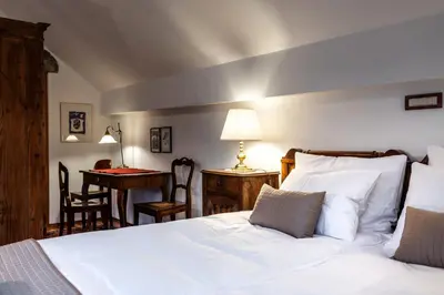 a bedroom with a bed and a desk with a desk at Historic lake view Bled apartment in Bled
