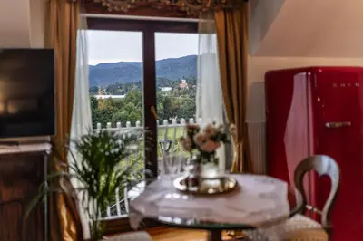 a table with a vase of flowers and a window at Historic lake view Bled apartment in Bled