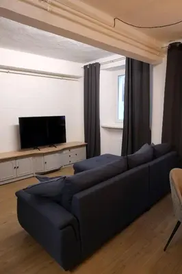 a living room with a couch and a flat screen tv at Apartment Emona - Old Town Ljubljana in Ljubljana