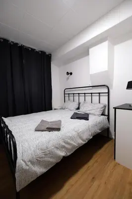 a bedroom with a large bed with black curtains at Apartment Emona - Old Town Ljubljana in Ljubljana