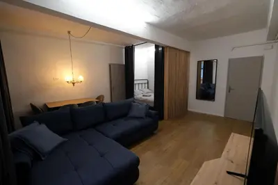 a living room with a blue couch and a table at Apartment Emona - Old Town Ljubljana in Ljubljana