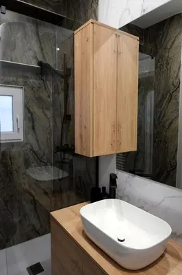 a bathroom with a white sink and a wooden cabinet at Apartment Emona - Old Town Ljubljana in Ljubljana