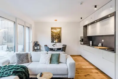 a living room with a white couch and a kitchen at Alps2sea Suite Apartment in Bovec