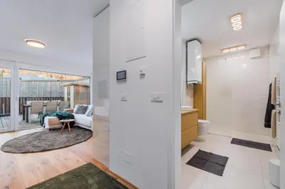 a living room with white walls and a sliding door at Alps2sea Suite Apartment in Bovec