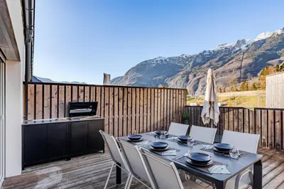 a table and chairs on a deck with a television at Alps2sea Suite Apartment in Bovec