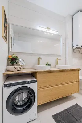 a washing machine in a bathroom with two sinks at Alps2sea Suite Apartment in Bovec