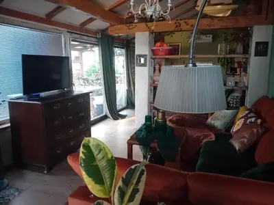 a living room with a couch and a television at ROSE ROOM for 4 guests in Rose resort Ljubljana in Ljubljana