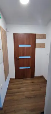 a room with a brown door and wooden floors at Apartma Mlinca 2 in Mojstrana