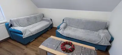 a room with two beds and a table with a wreath at Apartma Mlinca 2 in Mojstrana