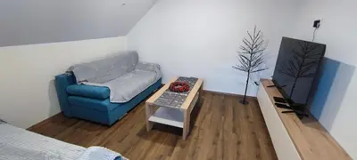 a living room with a blue chair and a table at Apartma Mlinca 2 in Mojstrana