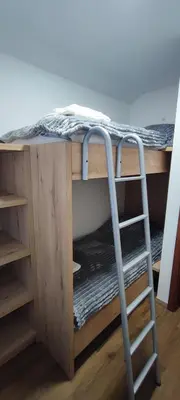 a ladder under a desk with a bunk bed at Apartma Mlinca 2 in Mojstrana