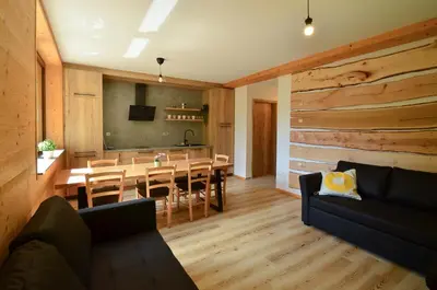 a living room with a table and a dining room at Apartmaji nad potokom in Železniki