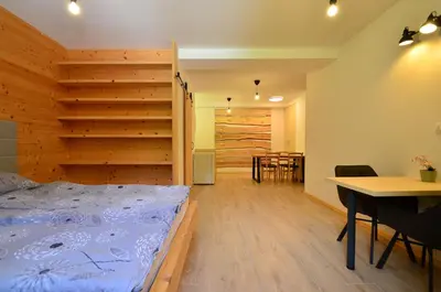 a bedroom with a bed and a table and a dining room at Apartmaji nad potokom in Železniki