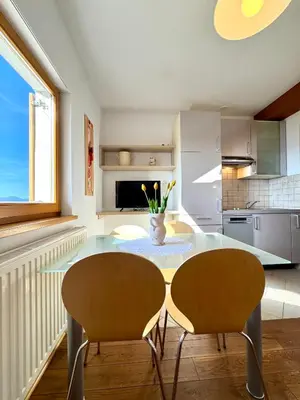 a kitchen with a glass table and two chairs at Apartments & Rooms Domacija Krnc in Hrib pri Hinjah