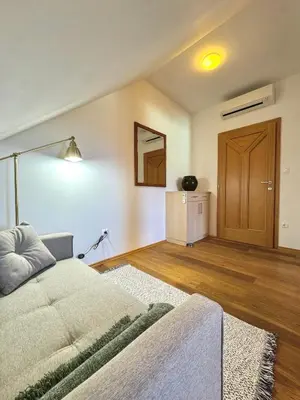 a living room with a bed and a wooden door at Apartments & Rooms Domacija Krnc in Hrib pri Hinjah