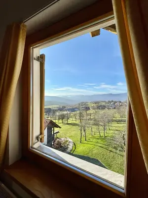 a window with a view of a field at Apartments & Rooms Domacija Krnc in Hrib pri Hinjah