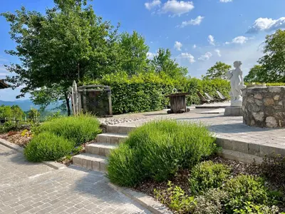 a set of stairs with a statue and grass at Apartments & Rooms Domacija Krnc in Hrib pri Hinjah