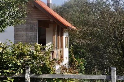 a wooden house with a fence in front of it at Apartments & Rooms Domacija Krnc in Hrib pri Hinjah