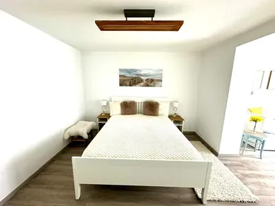 a white bedroom with a bed and a ceiling fan at New LunarGlow 3-room Apartment with free parking in Ljubljana