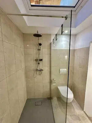 a bathroom with a toilet and a glass shower at New LunarGlow 3-room Apartment with free parking in Ljubljana