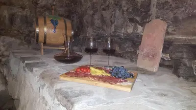 a table with a plate of food and two glasses of wine at Kraska hisa in Komen