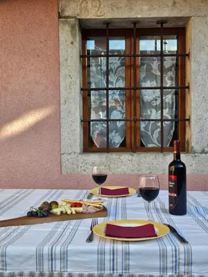 a table with two glasses and a bottle of wine at Kraska hisa in Komen