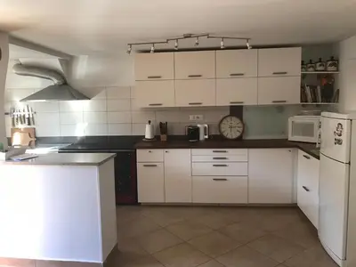 a kitchen with white cabinets and a white refrigerator at Kraska hisa in Komen