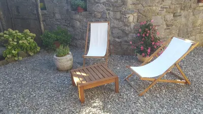 two chairs and a table and a mirror and flowers at Kraska hisa in Komen