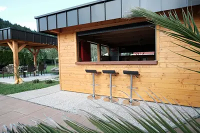 a building with three stools in front of a window at Kamp Nirvana in Šmartno ob Dreti