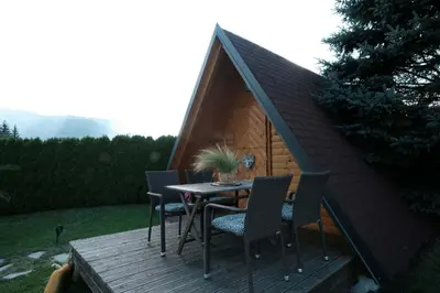 a table and chairs on a wooden deck with a tent at Kamp Nirvana in Šmartno ob Dreti
