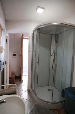 a glass shower in a bathroom with a sink at Kamp Nirvana in Šmartno ob Dreti