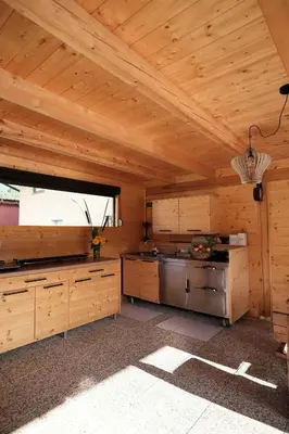 a large kitchen with wooden walls and a ceiling at Kamp Nirvana in Šmartno ob Dreti
