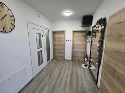 a hallway with wooden floors and a clock on the wall at Prenočišca Dany 4 in Dravograd