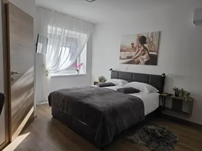 a bedroom with a large bed and a window at Prenočišca Dany 4 in Dravograd