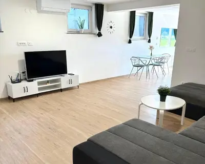 a living room with a couch and a tv at Pija's apartment, a quiet getaway close to Ljubljana in Vrhnika