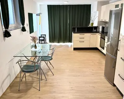 a kitchen with a glass table and chairs at Pija's apartment, a quiet getaway close to Ljubljana in Vrhnika