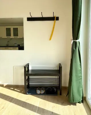 a living room with a table and a curtain at Pija's apartment, a quiet getaway close to Ljubljana in Vrhnika