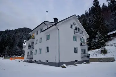 a large white building in the snow at Baguettes apartment in Oplotnica