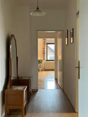 a hallway with a door and a mirror and a chair at Being eco in Ljubljana in Ljubljana