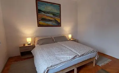 a bedroom with a bed and two night stands with lamps at Being eco in Ljubljana in Ljubljana