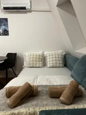 a bed in a room with two pillows on it at Eluma Apartments Bovec in Bovec