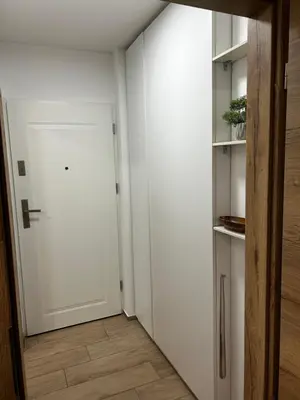 a hallway with a white door and a wooden floor at Eluma Apartments Bovec in Bovec