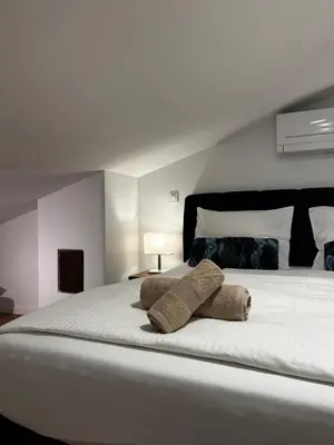 a large white bed with two pillows on it at Eluma Apartments Bovec in Bovec