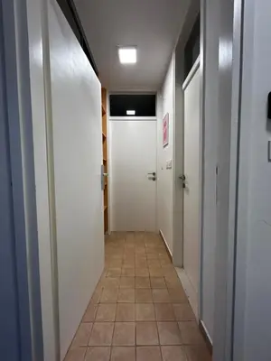 a hallway with white doors and a tile floor at Eluma Apartments Bovec in Bovec