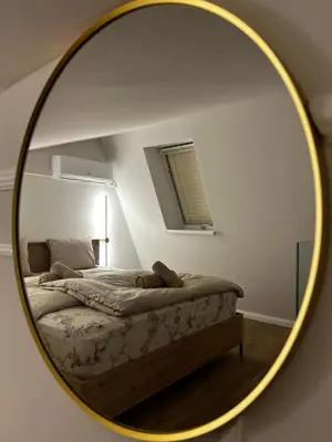 a mirror reflecting a bed in a bedroom at Velvet Alps Bovec in Bovec