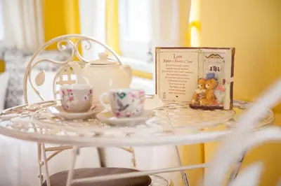 a white table with two cups and a tea set at Apartments Artorius Laško in Laško