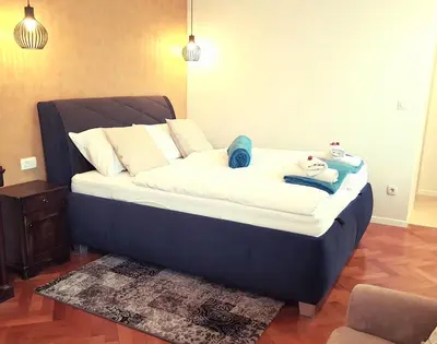 a large blue bed with two stuffed animals on it at Apartments Artorius Laško in Laško
