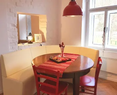 a dining room table and a couch with a table and chairs at Apartments Artorius Laško in Laško